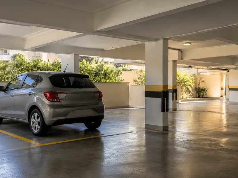 Garagem coberta de prédio com carro na vaga