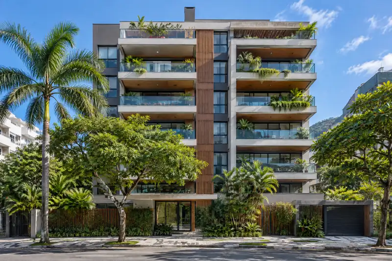 Prédio residencial moderno com varandas e árvores na calçada